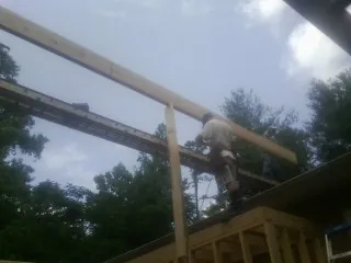 Carpenter setting a ridge beam over a new addition frame — Ice Dam Removal by Roofing Brothers in Los Angeles
