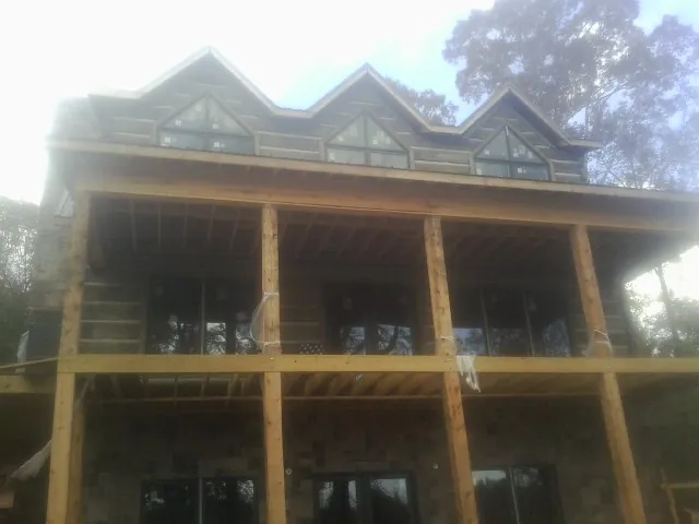 Dormers and porch framing on a large log home under construction — Roof Coating work by our crew in Los Angeles